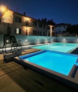 a swimming pool in front of a house at night at CÁ d ANGELO in Canove