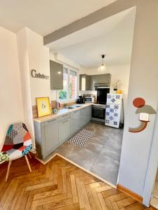 a kitchen with a sink and a refrigerator at Centre ville 2 chambres 4 voyageurs Tarif long séjour in Valenciennes +7 photos