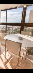 a white table and chairs in a room with a large window at Mediterranean Front Beach Apartment in El Puig