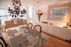 a dining room and living room with a table and chairs at Mediterranean Front Beach Apartment in El Puig