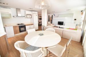 a kitchen and living room with a white table and chairs at Mediterranean Front Beach Apartment in El Puig