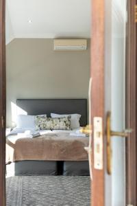 a bedroom with a bed with white pillows at Winelands Golf Lodges 12 in Stellenbosch +40 photos
