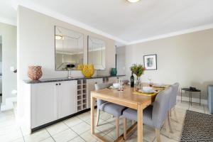 a kitchen and dining room with a wooden table and chairs at Winelands Golf Lodges 12 in Stellenbosch