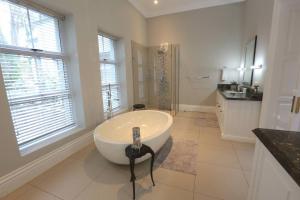 a white bathroom with a tub and a sink at Private Manor Estate Fly Fishing Sleeps 18 in Dullstroom +20 photos
