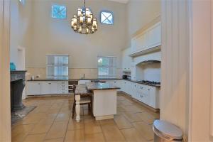 a large kitchen with a table and a chandelier at Private Manor Estate Fly Fishing Sleeps 18 in Dullstroom