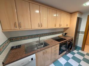 a kitchen with wooden cabinets and a sink at Piso Zentro Calatayud in Calatayud