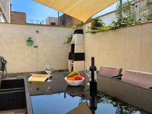 a table with a bowl of fruit and a bottle of wine at Ca La Fustereta in Figueres