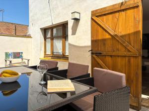 a patio with a table and a wooden door at Ca La Fustereta in Figueres
