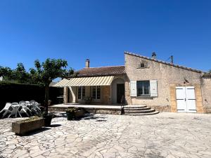 a house with a stone patio in front of it at Les oliviers du pradon in Lagarde-Paréol