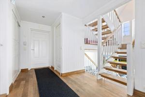 a hallway with white walls and a white staircase at Beach House With Multiple Terraces In Holmsbu in Holmsbu