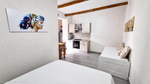 a white room with a bed and a kitchen at Sole E Mare in Marina di Fuscaldo