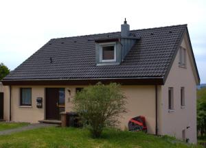 a white house with a black roof at Rose in Überlingen