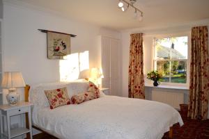 a bedroom with a white bed and a window at St Louan's in Alyth