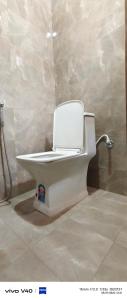 a white toilet in a bathroom in a room at Alliswell in Patna