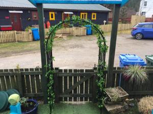 an arch with ivy on a wooden fence at Sleeps 2 includes breakfast in Garve