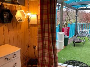 a room with a curtain and a patio with a table at Sleeps 2 includes breakfast in Garve