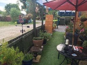 a garden with a table and an umbrella and plants at Sleeps 2 includes breakfast in Garve