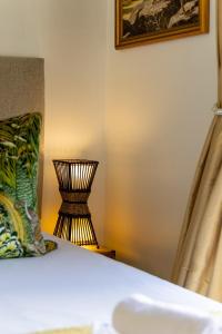 a lamp sitting on a table next to a bed at Winelands Golf Lodges 14 in Stellenbosch
