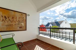 a balcony with a green chair and a window at Winelands Golf Lodges 14 in Stellenbosch +47 photos