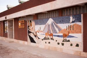 une peinture murale sur le côté d'un bâtiment dans l'établissement Hostal Anpaymi Atacama, à San Pedro de Atacama
