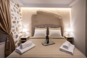 a bedroom with a large bed with towels on it at Cosmopolitan Suites in Parga