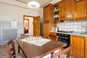 a kitchen with a table with chairs and a stove at Casa Corniolo Near Arezzo in Monte San Savino +15 photos