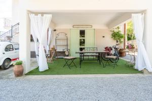 a patio with a table and chairs on grass at Casa Corniolo Near Arezzo in Monte San Savino