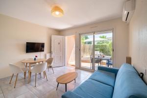 a living room with a blue couch and a table at Eden Azur - Résidence Hôtelière in Golfe-Juan