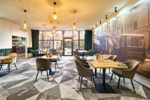 ein Restaurant mit Tischen und Stühlen und einem Wandgemälde an der Wand in der Unterkunft Mercure Cieszyn in Cieszyn