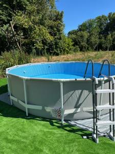 a bathtub sitting on the grass with a chair next to it at B & B Lmc LA MADONNINA CHALET in Casteggio