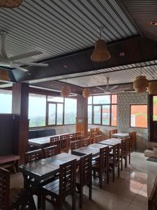 a dining room with tables and chairs and windows at Merjin's Paraiso in Vagamon