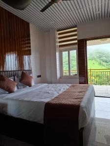 a bedroom with a large bed with a large window at Merjin's Paraiso in Vagamon