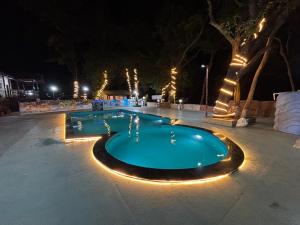 a swimming pool at night with lights around it at Meghdoot New Resort in Matheran