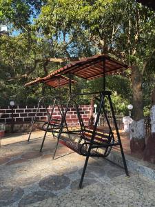 a swing set in a park with a tree at Meghdoot New Resort in Matheran