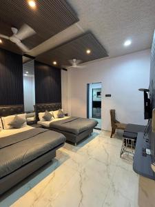 a bedroom with two beds and a desk in it at Meghdoot New Resort in Matheran