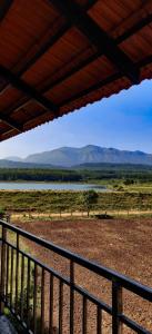 a view of a field with mountains in the distance at New Peak By The Lake in Chikmagalūr