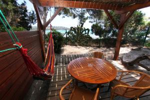 a porch with a hammock and a table and chairs at Résidence Mobydick in Porto-Vecchio
