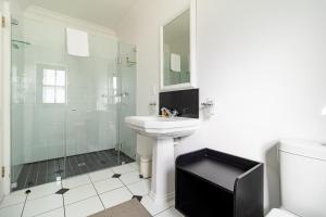 a white bathroom with a sink and a shower at Winelands Golf Lodges 15 in Stellenbosch