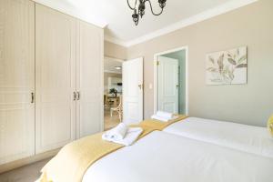 a bedroom with a large white bed with towels on it at Winelands Golf Lodges 15 in Stellenbosch