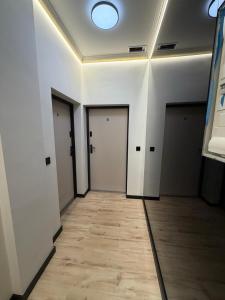 an empty hallway with doors and a wooden floor at Apartament Ania Nysa Centrum z bezpłatnym parkingiem in Nysa