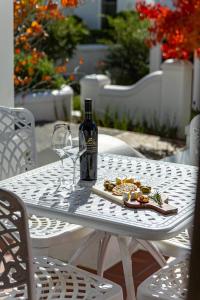 a bottle of wine and a plate of food on a table at Winelands Golf Lodges 15 in Stellenbosch