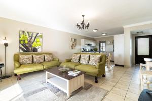 a living room with two couches and a table at Winelands Golf Lodges 15 in Stellenbosch +40 photos