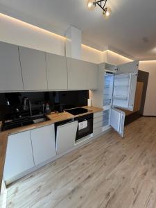 a kitchen with white cabinets and a wooden floor at Apartament Ania Nysa Centrum z bezpłatnym parkingiem in Nysa