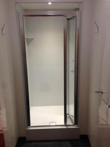 a glass shower door in a bathroom at Belsize House (Belsize Park) in London