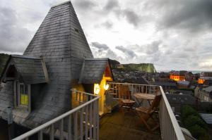 a house on a balcony with a view of a city at Le Loft du Clocheton in Étretat