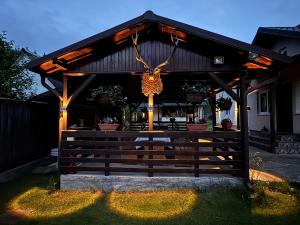 a wooden pavilion with a fence in a yard at Pensiunea Ana in Ceahlău +4 photos