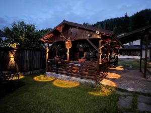 a building with a gazebo in a yard at Pensiunea Ana in Ceahlău