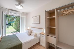 a bedroom with a bed and a large window at Villa Noa in Cala en Bosc
