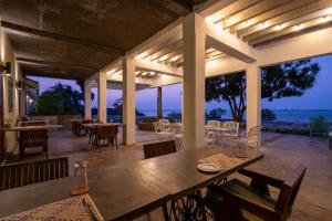 a patio with tables and chairs and a view of the ocean at Villa Sethawadi Hotel and Kitesurf Centre in Kalpitiya