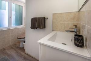 a white bathroom with a sink and a toilet at Chambre d'hotes 2 à Bramefort in Champsac